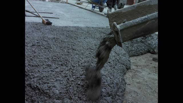 仰起水泥搅拌机在施工现场路面上浇筑混凝土视频素材