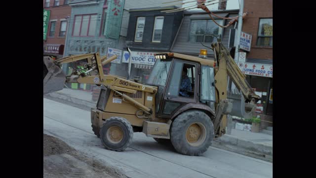 铲运机在街道上装载碎石的镜头视频素材