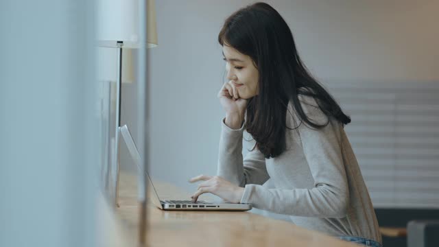 亚洲女学生在图书馆使用笔记本电脑视频素材
