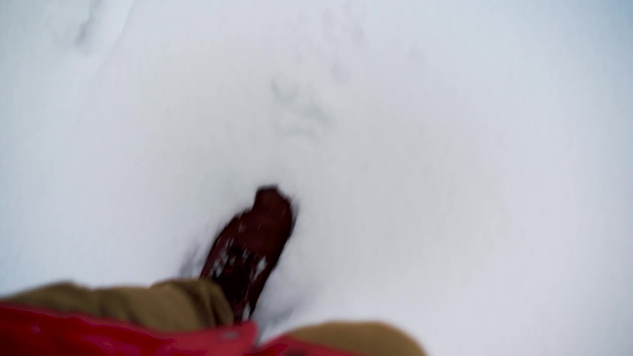头顶上的POV人徒步行走在雪道上，在山野的冬天。腿和鞋在雪地上踏的细节。视点4k视频视频素材