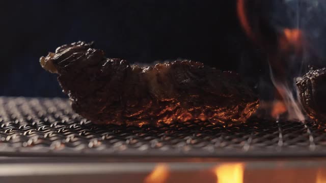 在火上烤牛排，用摄影车拍摄视频素材