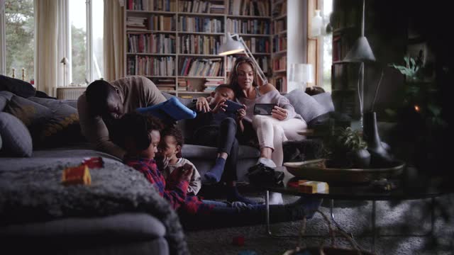 家人坐在客厅里使用无线技术的慢动作拍摄视频下载
