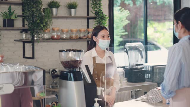 亚洲顾客戴着防护面具在咖啡馆排队等候付款和买咖啡视频素材