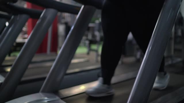 在健身房跑步机上跑步的年轻女子视频素材