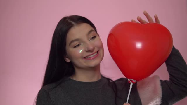 快乐女人用红心气球，庆祝圣瓦伦丁节。视频素材