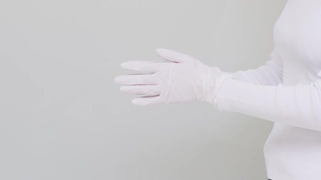近处女子脱下白色医用防护手套，竖起大拇指。在公共场所自我照顾，杜绝病毒观念视频下载