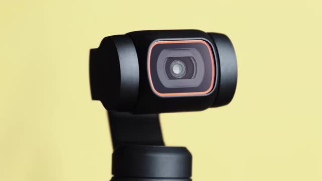 机械框架相机镜头旋转黄色背景，机器人相机微距视频素材