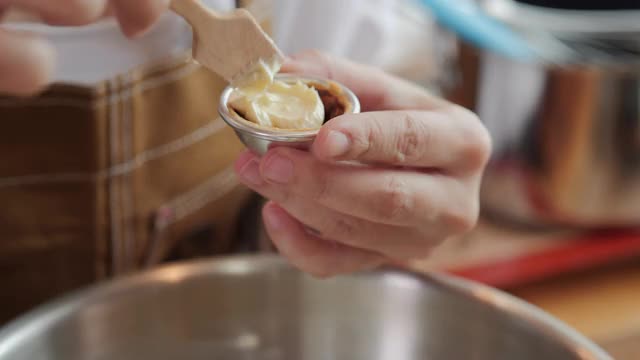 在糖果店用小的木制糕点铲将白色奶油填入模具。视频素材