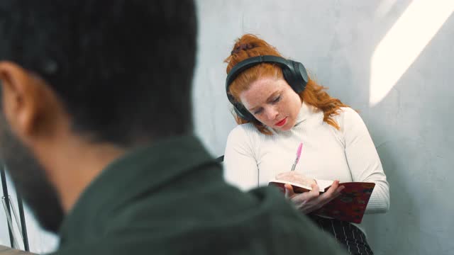 女企业家戴着耳机在工作场所用平板电脑工作视频素材