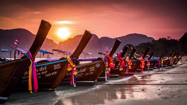甲米省美丽的夕阳下，传统的泰国长尾船。泰国的皮皮群岛。视频下载