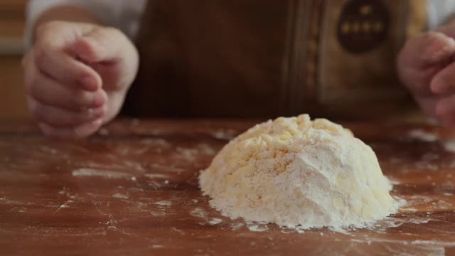 面包师在烘焙咖啡馆厨房的桌子上搅拌制作曲奇面团的原料。视频素材