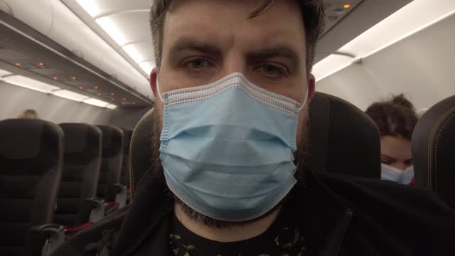 新冠肺炎大流行期间的飞机飞行。飞机上的蒙面人。特写镜头。视频素材