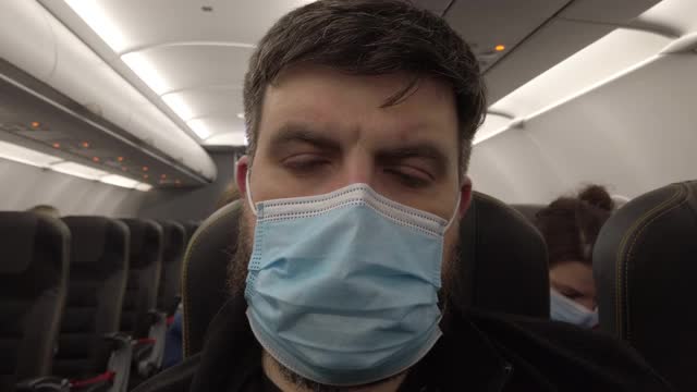 新冠肺炎大流行期间的飞机飞行。飞机上的蒙面人。特写镜头。视频素材