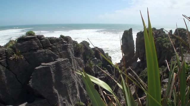 海浪在岩石海岸和山脉新西兰。视频素材