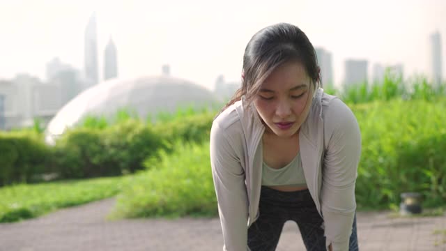 特写强壮的运动女子休息后在城市晨跑视频下载