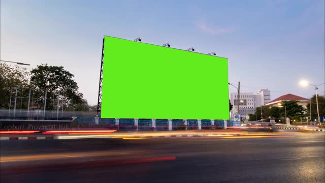 时间流逝的交通在晚上与空白的广告广告牌绿色屏幕。视频下载