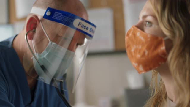 CU医生佩戴个人防护装备，用听诊器听诊女性患者肺部视频素材