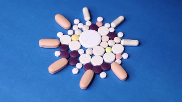 Covid-19冠状病毒治疗。蓝色背景的彩色药物治疗新型冠状病毒疾病。视频素材