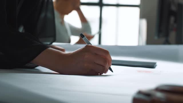 裁剪的手的女商人使用数字平板电脑，而同事在新的创意办公室工作视频素材