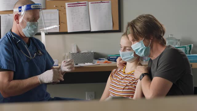 慈爱的父亲支持他的女儿作为一个医疗工作者接种疫苗视频素材