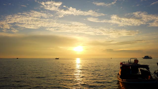 夏日日出时，海面上漂浮着一艘客船的剪影。视频素材