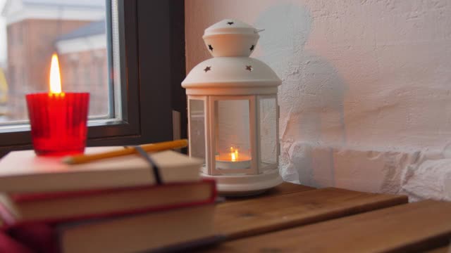 圣诞花环，书籍，蜡烛，灯笼在窗户上视频下载