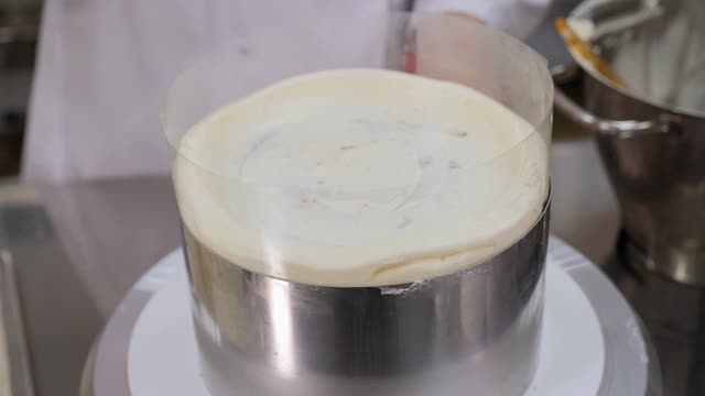糖果商用烹饪抹刀将白色奶油涂在饼干蛋糕上。视频素材