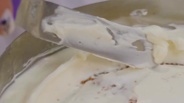 糖果商用烹饪抹刀将白色奶油涂在饼干蛋糕上。视频素材