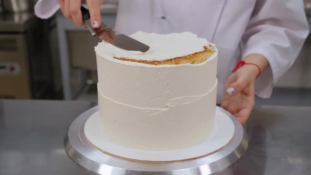 糕点师用金属刮刀将蛋糕顶部与奶油对齐。视频下载