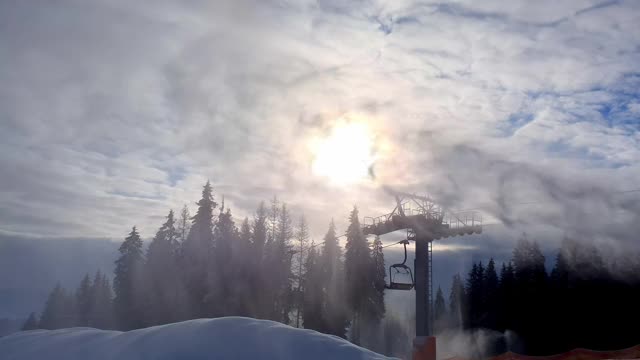 滑雪胜地的雪炮。造雪机在阳光和滑雪缆车的背景下制造人造雪。人工造雪的美妙景象。滑雪胜地的工作视频素材