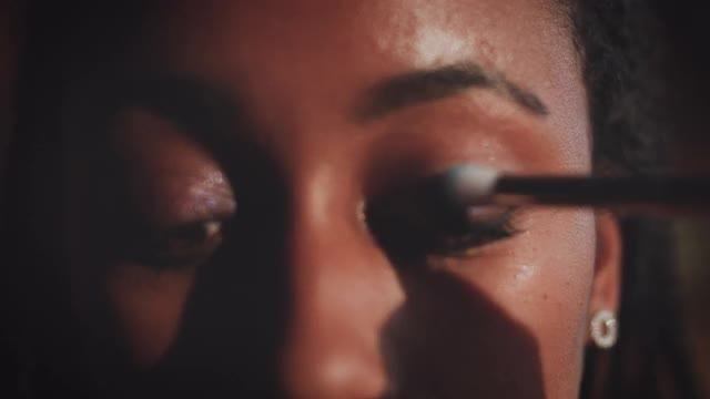 特写的年轻女性美容师通过刷眼影在视频博客教程视频素材