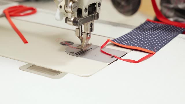 女裁缝在机器上用纺织品缝制自制面具视频素材