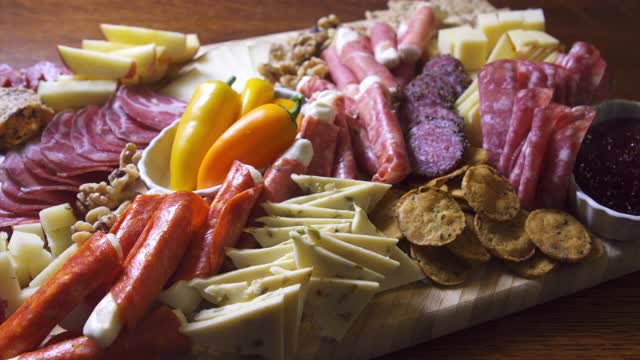 室内庆祝/派对上的一张桌子上的开胃菜熟食肉/奶酪板，上面有各种肉类，奶酪和饼干视频素材