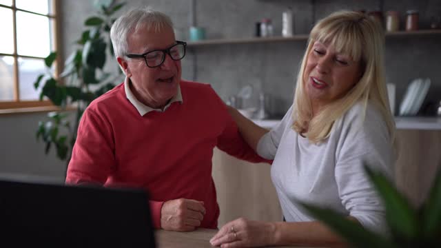 一对老年夫妇在家里用笔记本电脑进行视频通话视频素材