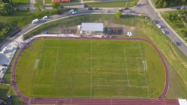 鸟瞰图上的足球场覆盖着绿色的草地在农村城镇地区。视频下载
