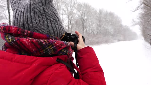 一名女子在拍摄冬季道路视频下载