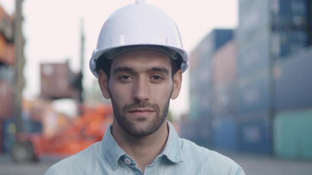 这是一幅微笑的中东民族商人或25岁男性工程师的肖像，他看着商业运输背景下充满信心的镜头。工作的骄傲概念。视频素材