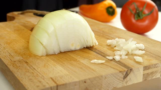 厨师用锋利的菜刀在切色拉的木板上切洋葱。健康饮食的概念。视频素材