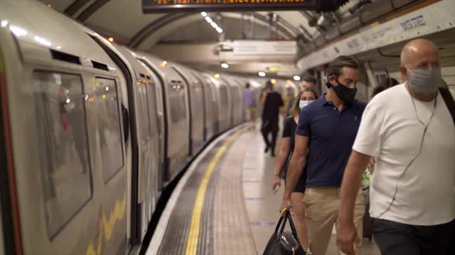 伦敦2021年地铁站台上有火车和蒙面乘客视频下载