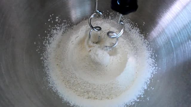 在立式搅拌机中搅拌面粉原料，用于烘焙、面包和蛋糕。用和面机准备用于烘焙的生面团。视频素材