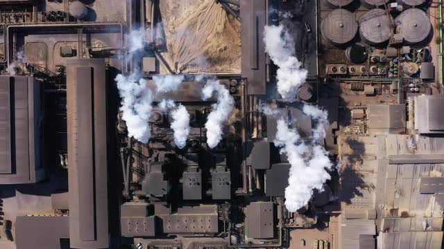 鸟瞰图的一个化工厂与冒烟的烟囱空气污染。环境问题，世界在工作无人机视图概念。视频下载