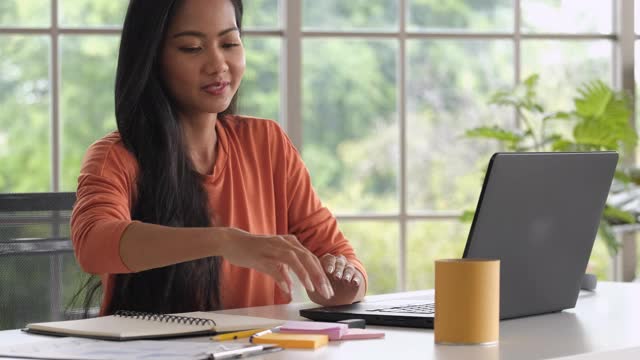 近距离亚洲妇女重新整理桌子上的东西和关闭笔记本电脑时，在家里完成工作视频素材