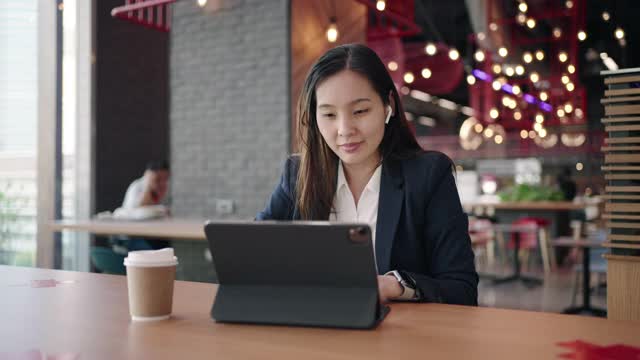 亚洲女商人在咖啡馆使用数字平板电脑视频素材