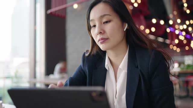 亚洲女商人在咖啡馆使用数字平板电脑视频素材
