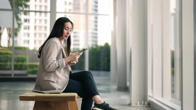 亚洲女商人使用智能手机视频素材