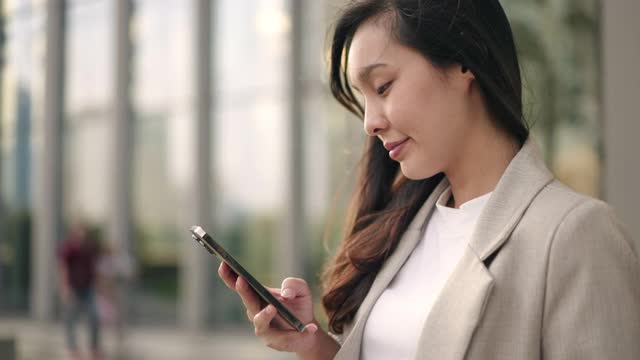 亚洲女商人使用智能手机视频购买
