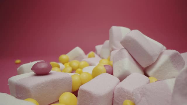 粉红色背景上孤立的糖果和棉花糖视频素材