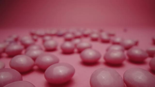 紫色和粉红色硬酸糖果孤立在粉红色的背景视频下载
