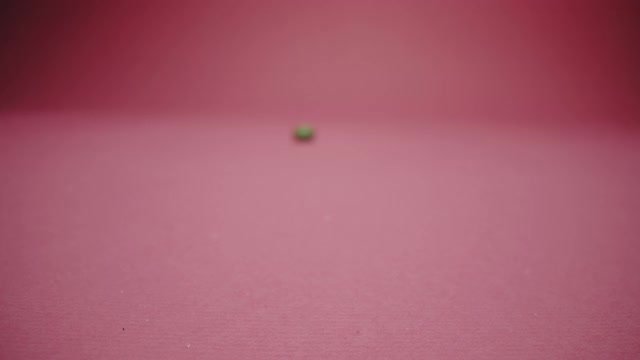 一个绿色的硬酸糖孤立在粉红色的背景上视频下载
