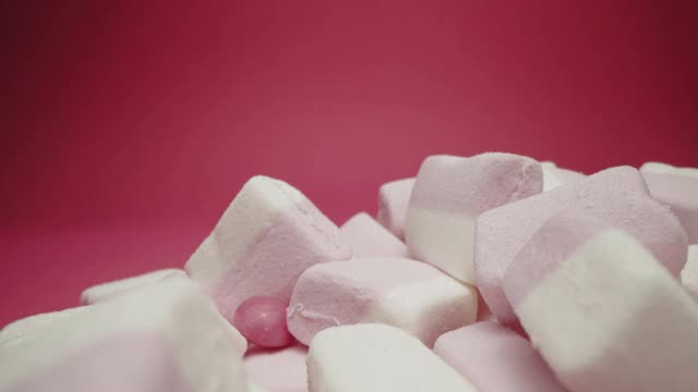棉花糖和酸糖孤立在粉红色的背景视频素材